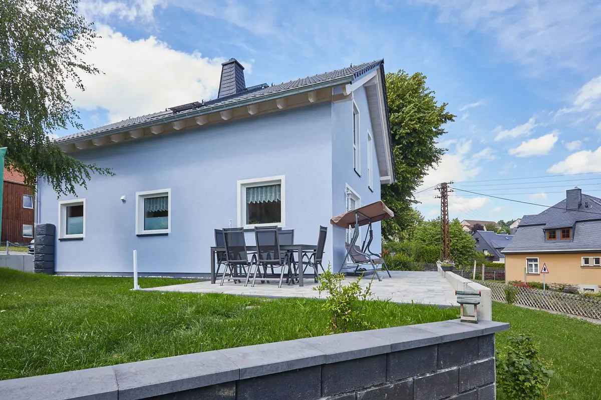 Holzhaus mit Putzfassade und Sichtbalkendecken