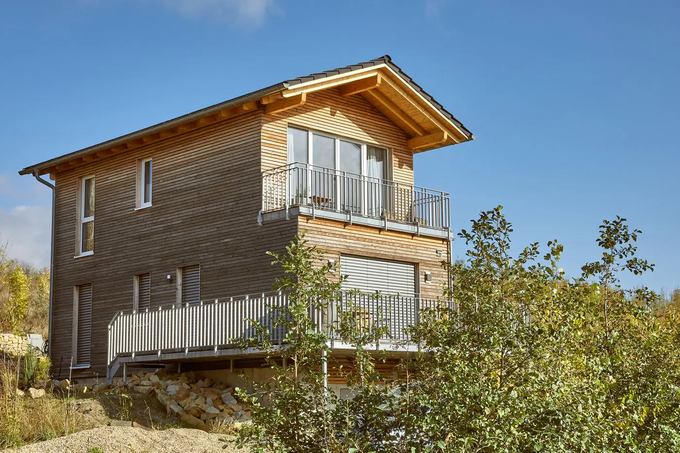 a wooden house with a balcony and trees