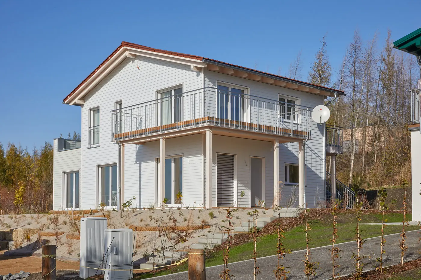 a white wooden house with a fence and a fenced yard